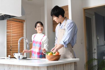 キッチンで料理をする若い夫婦（カップル）