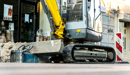 A bulldozer on the street digging a hole