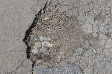 Schlagloch Straßenschaden im Asphalt gerissene Oberfläche 