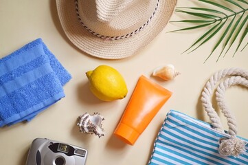Sea travel concept, beach essentials flat lay photo. Blue towel, straw hat, sunscreen, camera and...