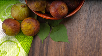 Freshly ripe figs. Healthy Mediterranean fig fruit. Fresh figs on a dark background. Beautiful blue violet figs with leaves, copy space, closeup