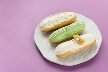 Traditional French dessert. Sweet and colorful eclairs with chocolate glaze.
