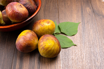 Freshly ripe figs. Healthy Mediterranean fig fruit. Fresh figs on a dark background. Beautiful blue violet figs with leaves, copy space, closeup