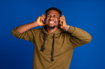 Naklejka premium African American man with headphones on blue background
