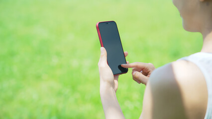 屋外でスマートフォンを使う女性