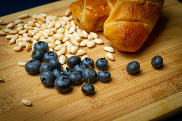 blueberries with pintch of puffed rice and small sweet bakes all shown on bamboo cutting board