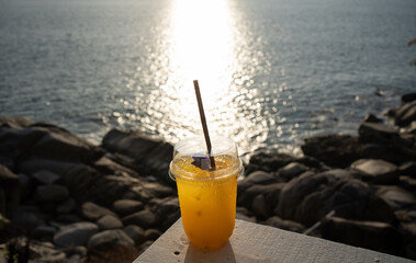 glass of orange juice on the beach