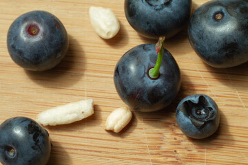blue berries with some seeds of puffed rice on the bamboo cutting board