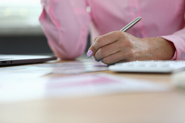 Online education woman analyzes data on sample graphs and writes answers in notebooks