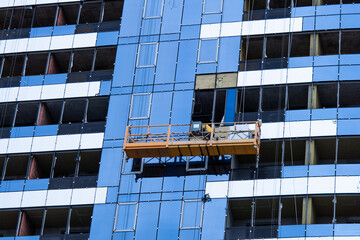 High-rise construction. Installation of a high-rise building. Concrete, steel, glass and man...