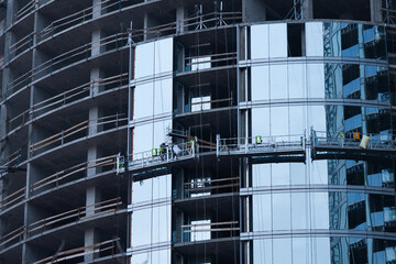High-rise construction. Installation of a high-rise building. Concrete, steel, glass and man...