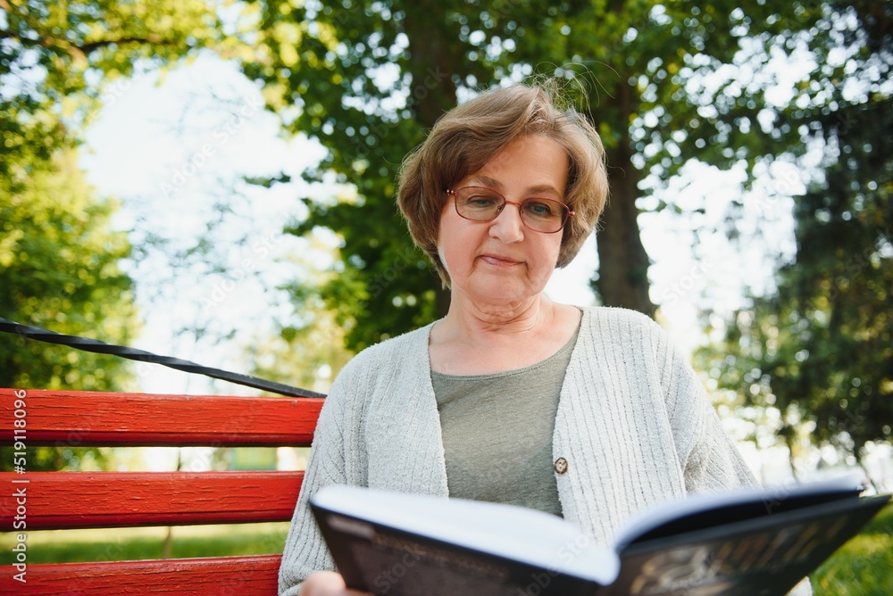 Poster Retired woman reading a book on the bench