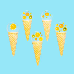 Ice cream cones with slices of fresh tropical fruits, reflected in a glass sphere on bright blue background. Summer vibes, tropical fruit composition.