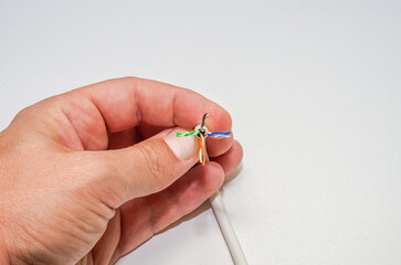 A computer wizard strips the wires of an Internet cable for connecting a twisted pair cable to a...
