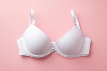 Breast cancer awareness concept. Top view photo of white brassiere on isolated pastel pink...