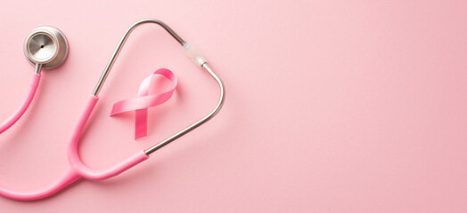 Breast cancer awareness concept. Top view photo of stethoscope and pink silk ribbon on isolated pastel pink background with copyspace