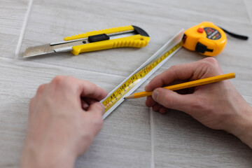 Man hands measuring decorative plastic corner. Repairing at home.