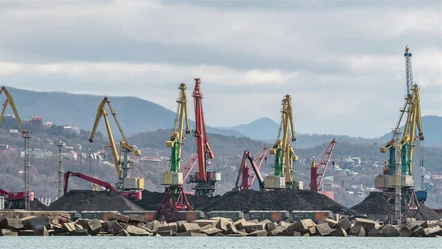 The cranes are loading bulk materials and coal in the seaport. Timelapse.