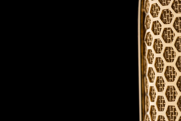 Part of the mesh of a gold plated ribbon microphone on a black background Nr.6