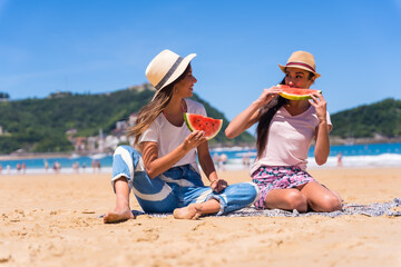 Fototapeta na wymiar Friends in summer on the beach eating a watermelon
