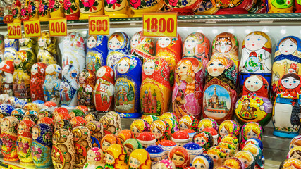 Fototapeta na wymiar Rows of the Russian puzzle nesting dolls or Matryoshka dolls on display shop in the market. Selective focus.