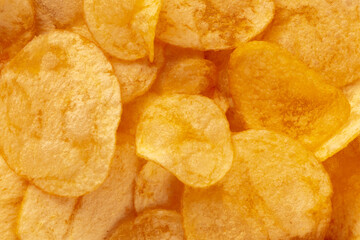 Potato chips texture, a salty snack, a pile of yellow crisps, top shot
