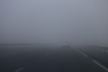 car driving in fog on the road