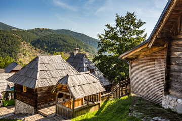 Fototapeta na wymiar The roofs of wooden country houses with a scenery mountain view in the background. Serbia
