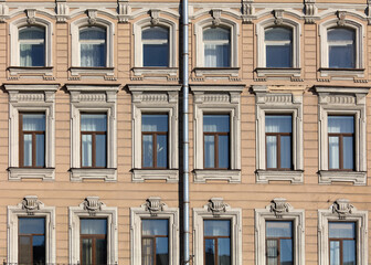 Fototapeta na wymiar Windows on the wall of an old high-rise building.