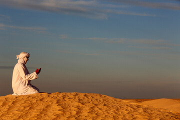 Beduin praying in the Sahara - obrazy, fototapety, plakaty