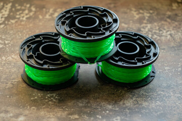 Three replacement green nylon trimmer lines and spools
