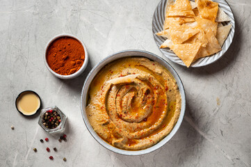 Traditional arabian eggplant dip baba ganoush with herbs and smoked paprika on light background....