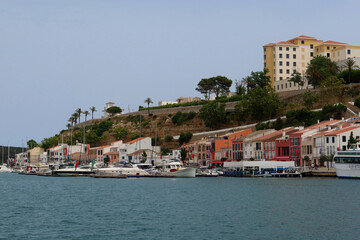 Fototapeta premium Mahon (Mao), Minorca (Menorca), Spain. Port of Mahon - the largest natural port in the Mediterranean Sea. Small islands, fortifications, villas, boats make beautiful scenery. View from the cruise boat
