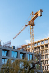 Tower crane at a construction site, construction of a residential building, construction. Heavy industry concept. Construction site with a crane. Construction site background. Multi-storey building