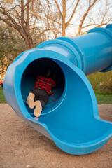 The girl rolls down the hill. Sliding down. Large children's slide-tube. children's playground....