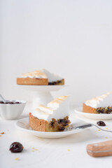 Sand cake with cherries. White background with dessert. Baking with meringue. The pie is cut.