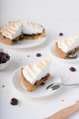 Sand cake with cherries. White background with dessert. Baking with meringue. The pie is cut.