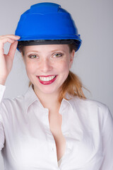 Young smiling female engineer wearing a blue hard hat