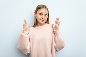Young caucasian girl isolated on blue background laughs out loudly keeping hand on chest.