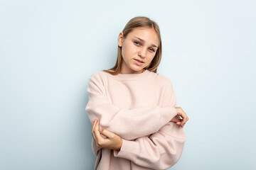 Obraz premium Young caucasian girl isolated on blue background massaging elbow, suffering after a bad movement.