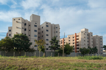 Urban scene shows residential apartment blocks, trees and land in the foreground, Piracicaba SP Brasil.