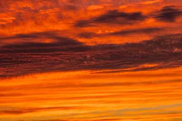 Fototapeta na wymiar Orange and red sky at sunset and dawn. structure and texture of clouds. different shapes and types of sky. Photo and wallpaper on the desktop. beautiful transfusion of colors and smooth transition.