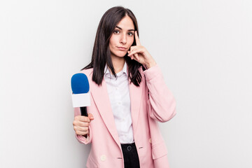 Young TV presenter caucasian woman isolated on white background pointing temple with finger, thinking, focused on a task.