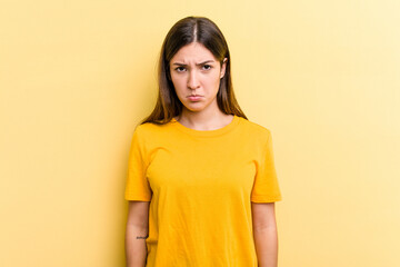 Obraz premium Young caucasian woman isolated on yellow background sad, serious face, feeling miserable and displeased.