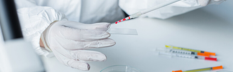 Cropped view of scientist working with glass and pipette in lab, banner.