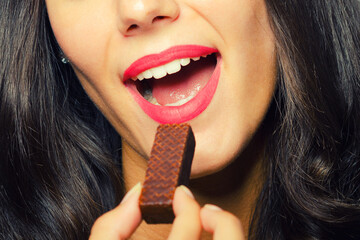 Portrait of the beautiful girl eating chocolate cookies