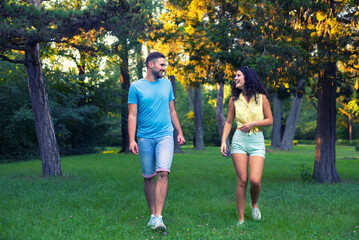 Young couple walking in the park on a beautiful summer day