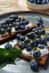 Fruity topped bread with blueberries on Greek yogurt. Healthy toast (tartine). 