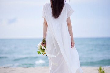 ドレスを着て花束を持つ若い日本人女性