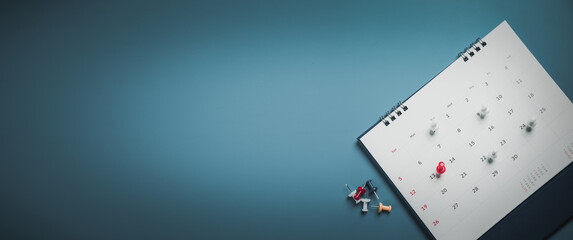 Embroidered red pins on a calendar event Planner calendar,clock to set timetable organize schedule,planning for business meeting or travel planning concept.
